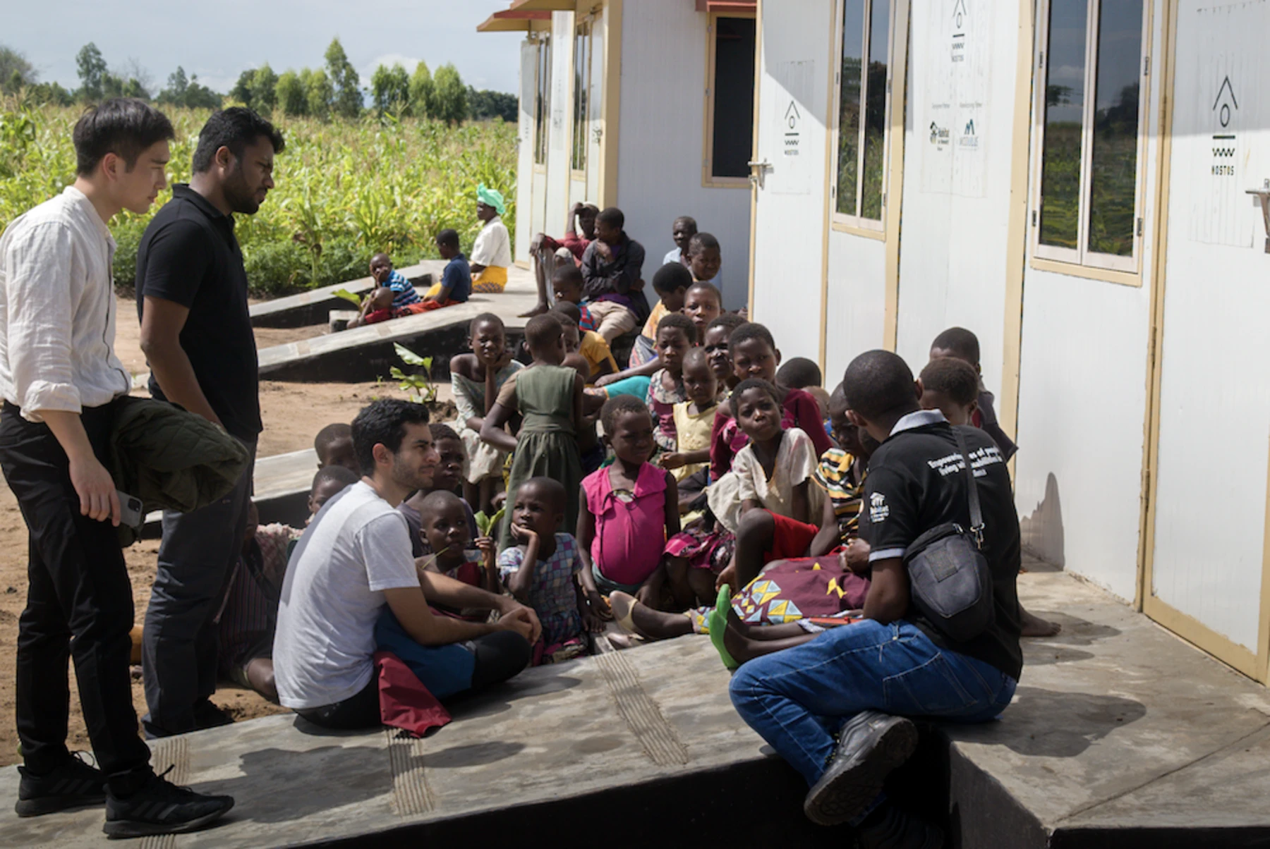 project leaders and people sitting in front of building